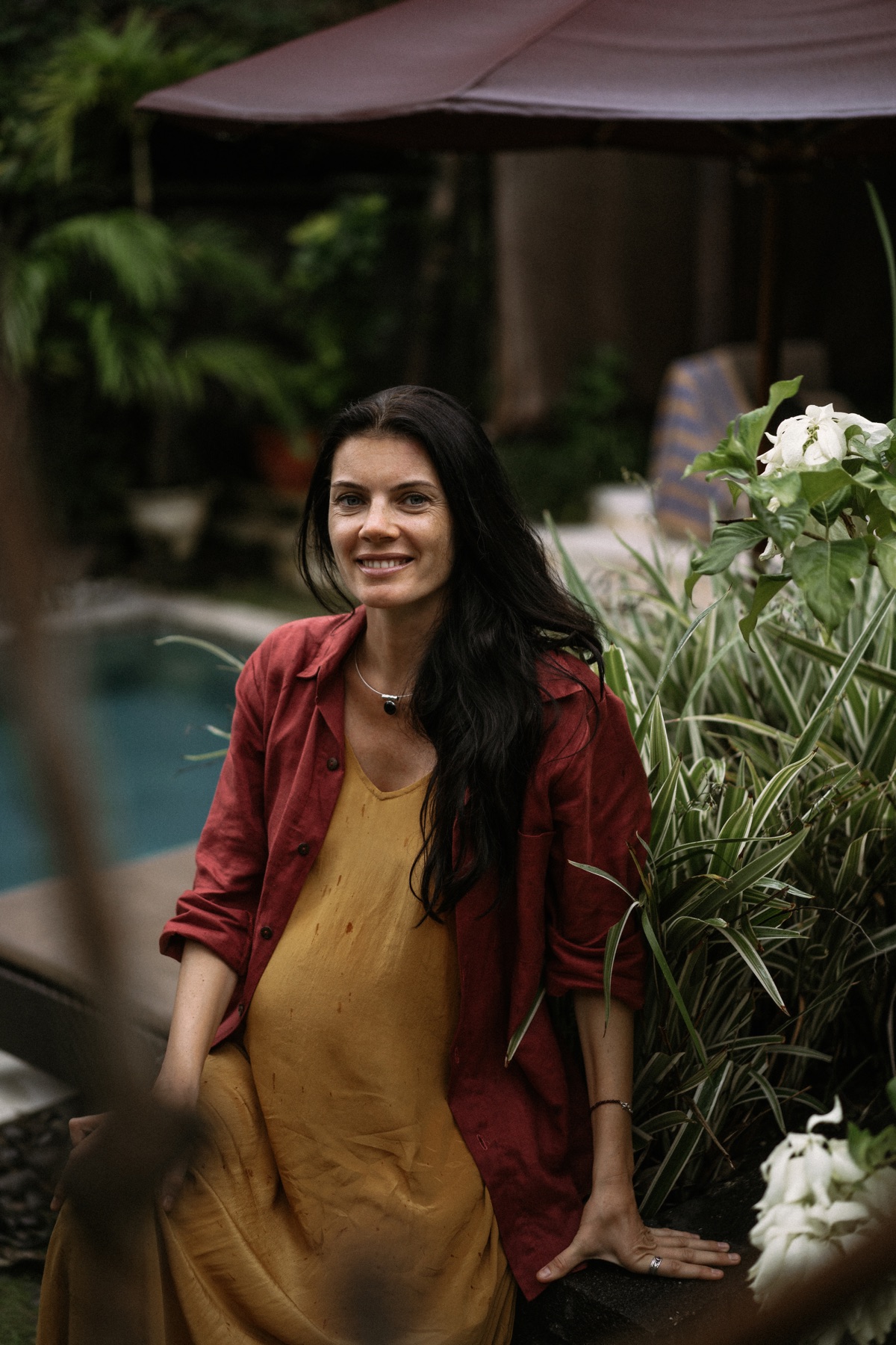 Pregnant woman standing in a tropical garden